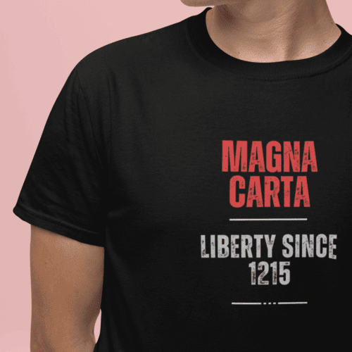 Wearing the Magna Carta T-Shirt: Liberty Since 1215, a person stands against a pink background, looking to the side.