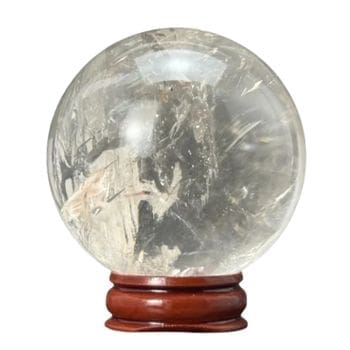 The Natural White Transparent Quartz Crystal Ball is ideal for meditation, therapy, aura work, witchcraft, or home and office decor. Features natural inclusions and comes with a round wooden stand. Perfect for energy or aquarium decoration.