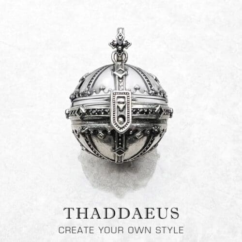 A detailed silver Pendant Kingdom of Dreams Orb with ornate designs and a clasp, displayed on white marble. Below, the text reads: THADDAEUS CREATE YOUR OWN STYLE, inspired by the Pendant Kingdom of Dreams Orb.