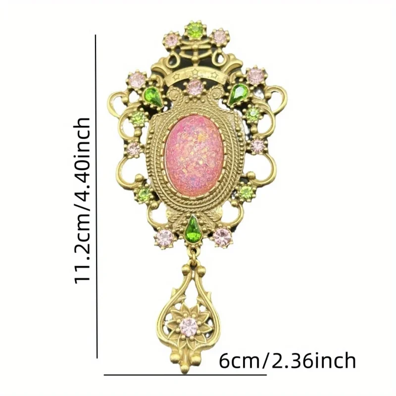 The Baroque Large Vintage Gemstone Brooch features a pink opal-like center, surrounded by pink and green gem accents in ornate gold metalwork, finished with a decorative gold dangle set with a pink gem.
