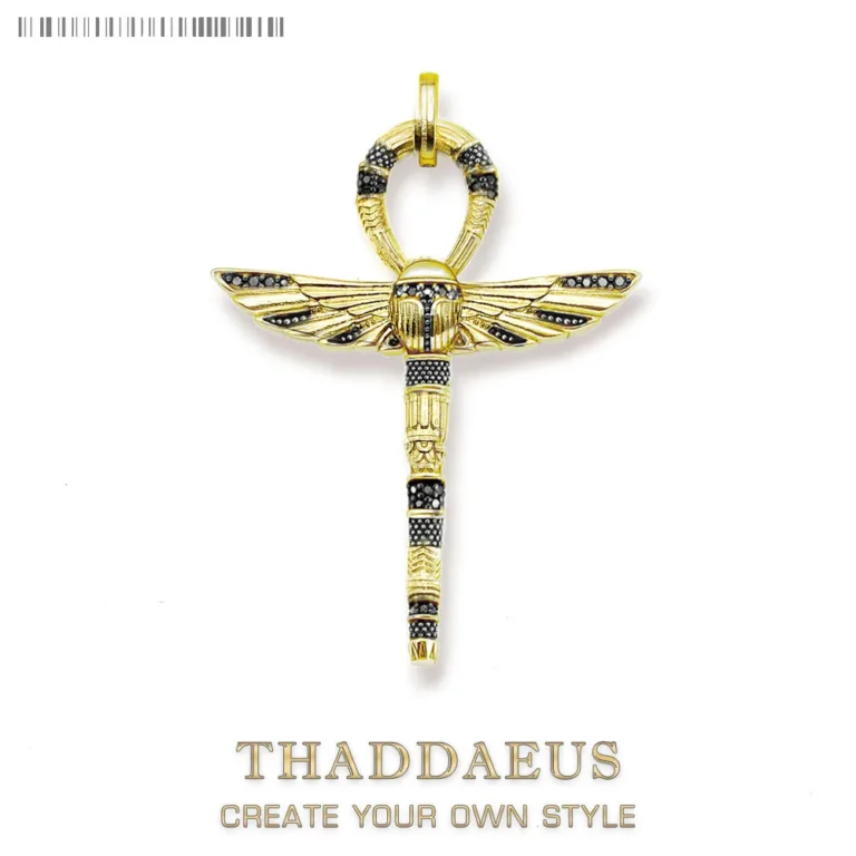 The THADDAEUS Pendant Cross of Life Ankh with Scarab features a gold and black ancient Egyptian-inspired design, resembling a winged staff with a loop on top. CREATE YOUR OWN STYLE appears below the brand name.