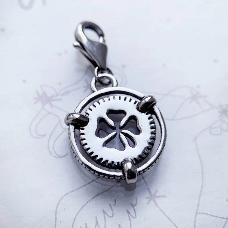 The Lucky Clover Dangle Charm Pendant features a silver clover cutout center and lobster clasp