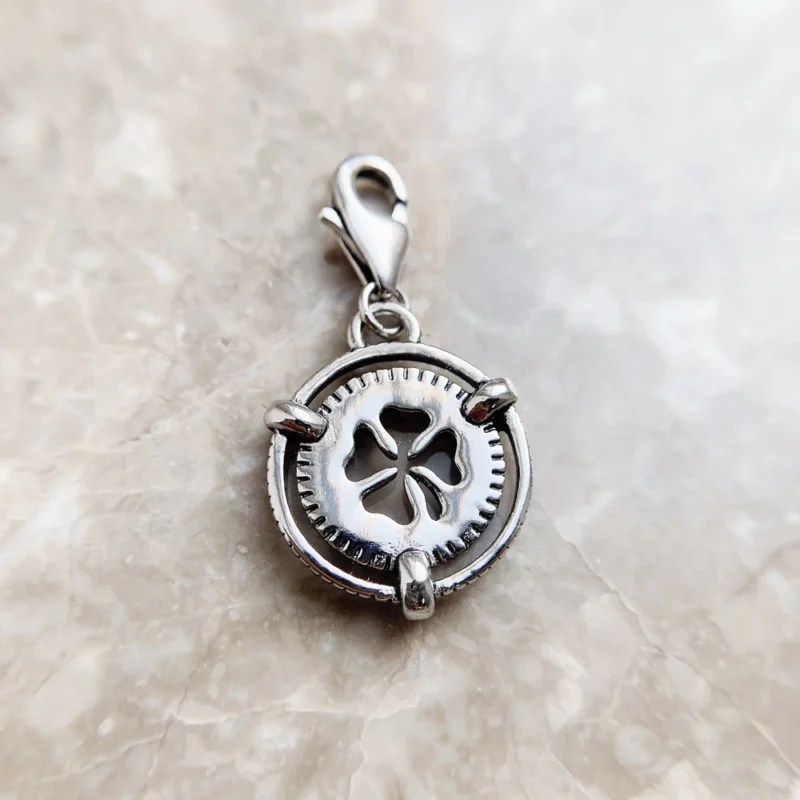 The Lucky Clover Dangle Charm Pendant features a silver clover cutout center and lobster clasp