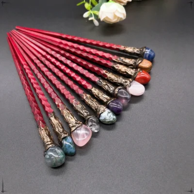 A set of ten 19CM natural crystal stone magic wands with spiral handles and ornate bases, each topped with a unique crystal like amethyst or tiger eye, are arranged in a fan shape on a dark surface with flowers behind.