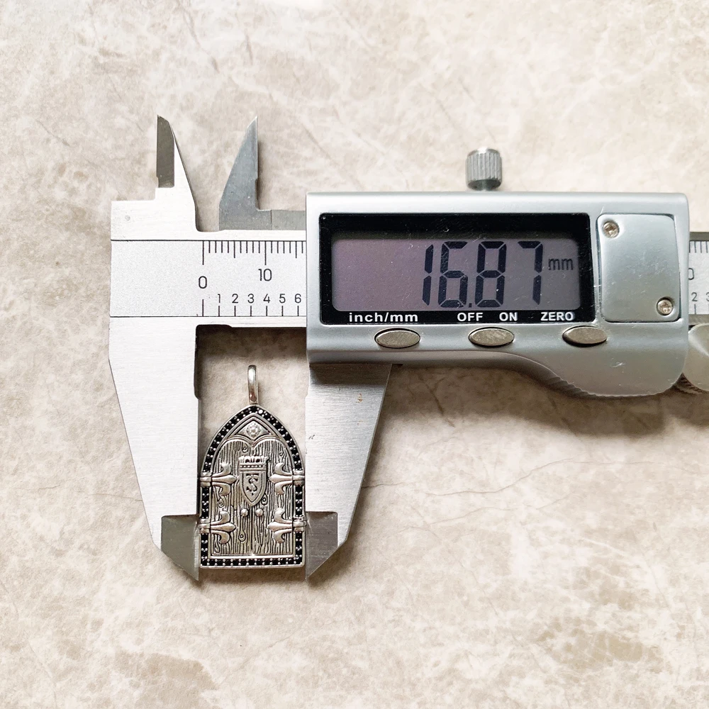 A Vintage Window Pendant shaped like a medieval arched door features engraved birds and shield details