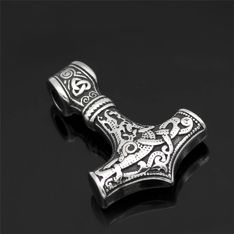 The Thor’s Viking Hammer Amulet Necklace | Norse Mythology Jewellery, featuring Norse-inspired designs, is displayed elegantly on a glossy black surface.